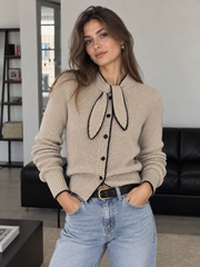 Cardigan col lavallière laine beige — vue portée de face, jean bleu clair, en intérieur