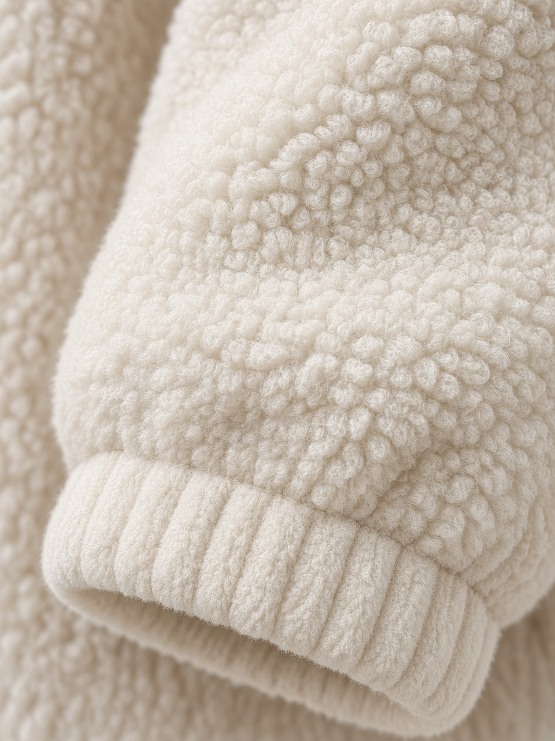 Sweat écru à col zippé — détail du poignet sherpa