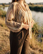 Blouse imprimée à manches ballon portée par une femme, vue rapprochée, manche ballon, rivière