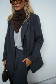 Blazer doublé à épaulettes gris porté par une femme, vue rapprochée, foulard marron, lunettes de soleil