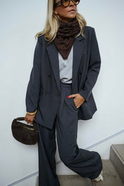 Blazer doublé à épaulettes gris porté par une femme, vue de face, lunettes de soleil, foulard marron