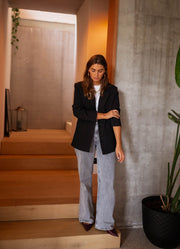 Blazer doublé à épaulettes noir porté par une femme, silhouette entière, escalier, jean