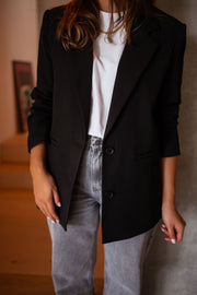 Blazer doublé à épaulettes noir porté par une femme, vue rapprochée, t-shirt blanc, jean