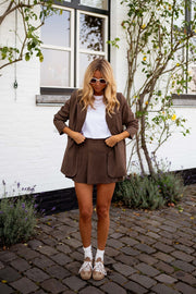 Blazer ample doublé à épaulettes chocolat porté par une femme, vue de face, short assorti, baskets