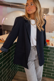 Blazer long doublé ample bleu porté par une femme, vue de face, comptoir vert, jean gris