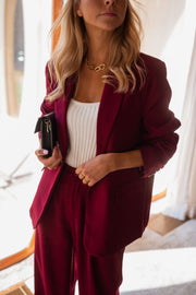 Blazer droit doublé à épaulettes bordeaux porté par une femme, vue rapprochée, pochette, haut blanc, autre cadrage