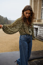 Blouse à pois col V portée par une femme, vue de face, esplanade, manches bouffantes