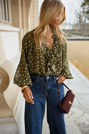 Blouse à pois col V portée par une femme, vue de face, sac bordeaux, jean large