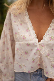 Blouse fleurie à décolleté dentelle portée par une femme, vue rapprochée, décolleté dentelle