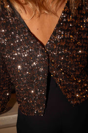Blouse doublée à dos ouvert portée par une femme, vue rapprochée, dos en V, paillettes