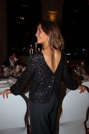 Blouse à dos ouvert boutonné portée par une femme, vue de face, table dressée, sourire