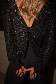 Blouse à dos ouvert boutonné portée par une femme, vue rapprochée, dos ouvert, paillettes