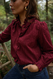 Blouse brodée à col volanté bordeaux portée par une femme, vue rapprochée, col, cheveux bruns