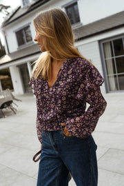 Blouse fluide à col V portée par une femme, vue de trois-quarts, manches bouffantes, jean