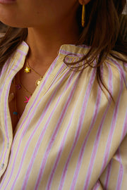 Blouse rayée à manches ballon portée par une femme, vue rapprochée, col, collier