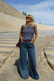 Blouse froncée sans manches portée par une femme, silhouette entière, lunettes de soleil, de face