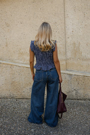 Blouse froncée sans manches portée par une femme, vue de dos, silhouette entière