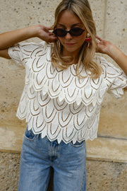 Blouse crochet manches courtes portée par une femme, vue rapprochée, lunettes de soleil, mains dans les cheveux
