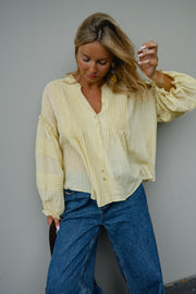 Blouse douce ample boutonnée portée par une femme, vue rapprochée, main dans les cheveux