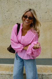 Blouse boutonnée à manches évasées portée par une femme, vue rapprochée, lunettes de soleil, sourire