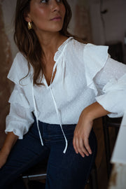 Blouse plumetis à volants écrue portée par une femme, vue rapprochée, volants, cordon