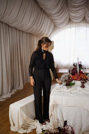 Body léopard à col montant porté par une femme, vue de face, fenêtre, pantalon noir