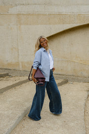 Chemise épaisse col classique portée par une femme, en marchant, sac bordeaux, sur des gradins