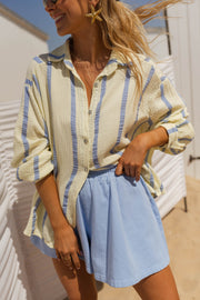 Chemise rayée en gaze portée par une femme, vue rapprochée, rayures, short bleu