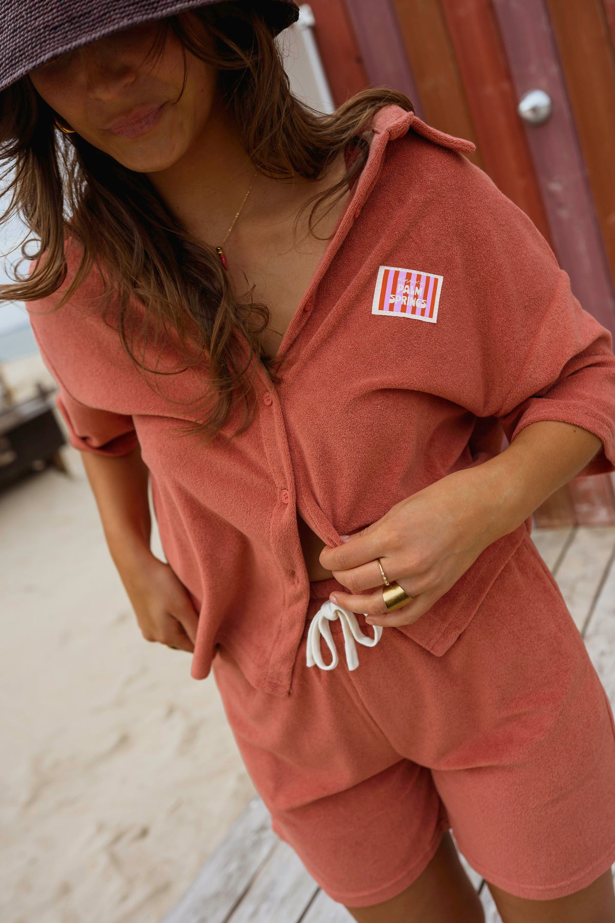 Chemise éponge loose portée par une femme, vue rapprochée, short assorti, étiquette