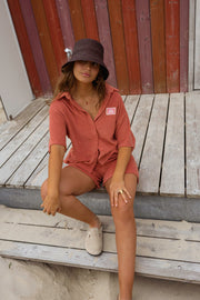 Chemise éponge loose portée par une femme, assise, ponton, short assorti