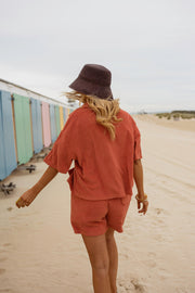 Chemise éponge loose portée par une femme, vue de dos, chapeau, short assorti