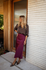 Chemise satinée fluide chocolat portée par une femme, vue de face, porte, escarpins