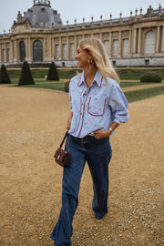 Chemise rayée brodée à cerises portée par une femme, en marchant, palais, esplanade
