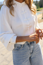 Chemise transparente à brandebourgs portée par une femme, vue rapprochée, mains sur la chemise