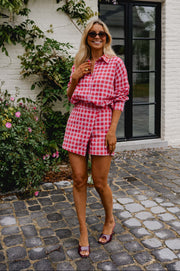 Chemise à carreaux brillante portée par une femme, silhouette entière, short assorti, sur des pavés