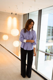 Chemise ample à carreaux portée par une femme, vue de face, couloir, lampes