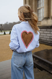 Chemise rayée dos cœur ouvert portée par une femme, vue de dos, cœur découpé, cheveux blonds