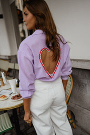 Chemise rayée à dos ouvert portée par une femme, vue rapprochée, ouverture en cœur dans le dos