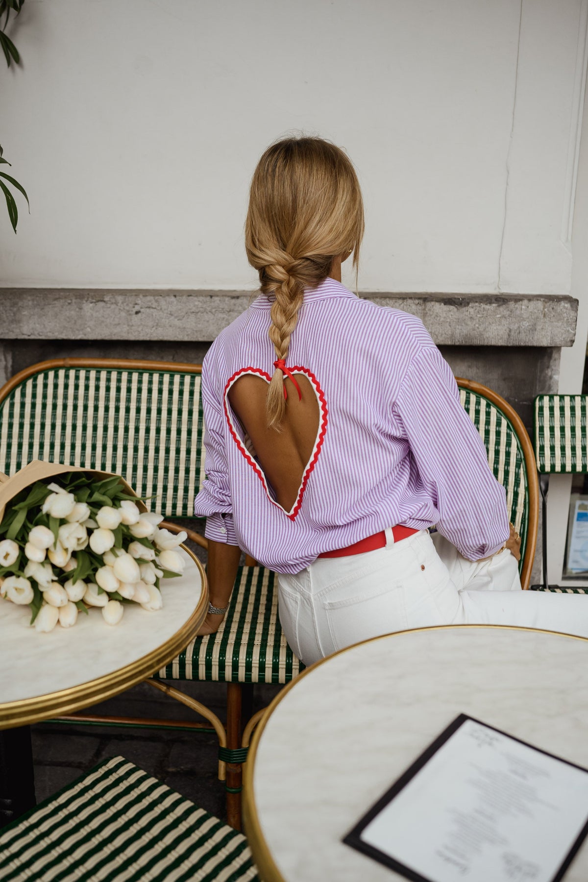 Chemise rayée à dos ouvert portée par une femme, vue de dos, ouverture en cœur dans le dos, terrasse