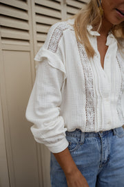 Chemise en gaze brodée portée par une femme, vue rapprochée, épaulettes à volants, empiècement dentelle