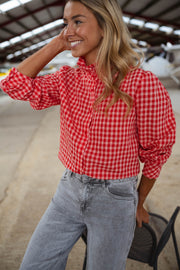 Chemise vichy col victorien portée par une femme, vue rapprochée, vichy rouge, sourire