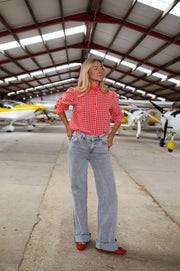 Chemise vichy col victorien portée par une femme, vue de face, hangar, avion jaune
