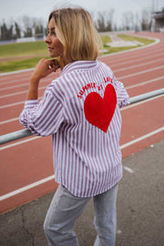 Chemise rayée à manches longues portée par une femme, vue de dos, cœur rouge, piste rouge