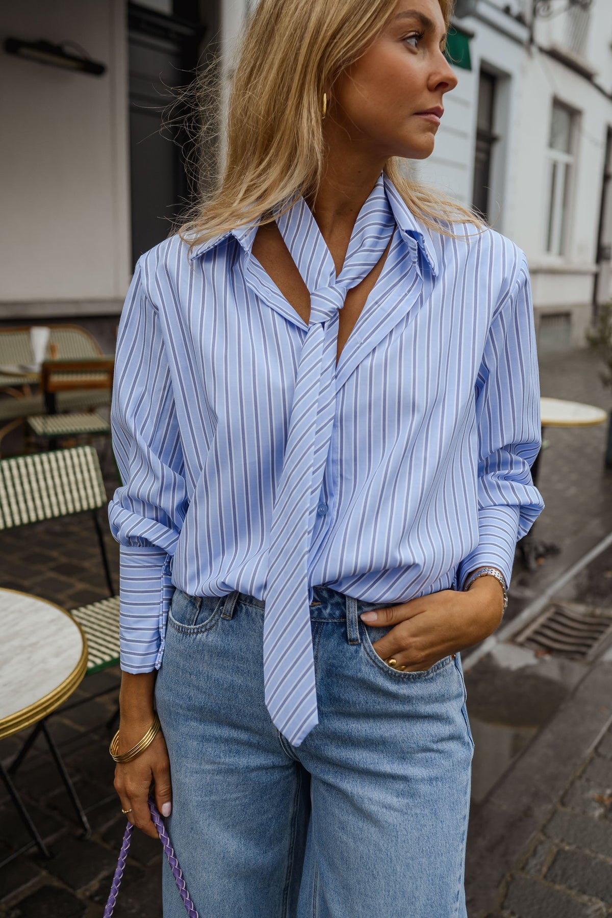 Chemise rayée à cravate portée par une femme, vue rapprochée, col noué, jean