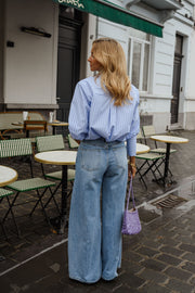 Chemise rayée à cravate portée par une femme, silhouette entière, jean large, rue