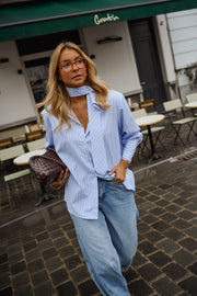 Chemise rayée à cravate portée par une femme, vue rapprochée, lunettes, foulard noué au cou