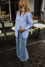 Chemise rayée à cravate portée par une femme, vue de profil, jean large
