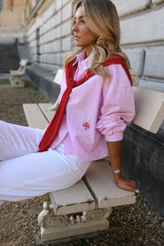 Chemise rayée à revers amovible portée par une femme, assise, sur un banc, vue rapprochée