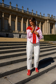Chemise rayée à revers amovible portée par une femme, silhouette entière, sur des escaliers, baskets rouges