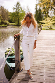 Chemise à cœurs manches longues portée par une femme, vue de face, ponton en bois, pantalon blanc